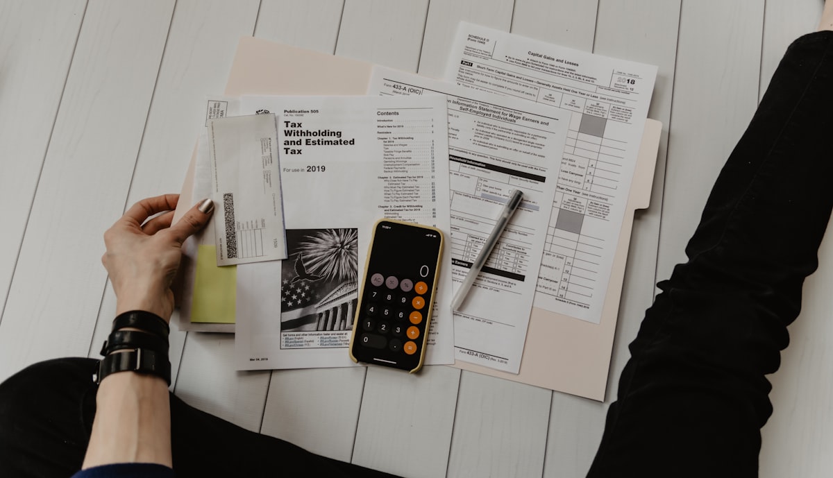 Accountant working with financial documents and calculator on desk